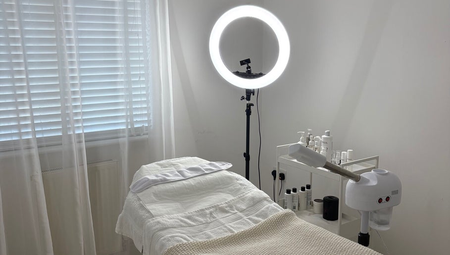 Serene treatment room at SknandSculpt, Ely, England, GB, featuring a cozy bed and skincare products.