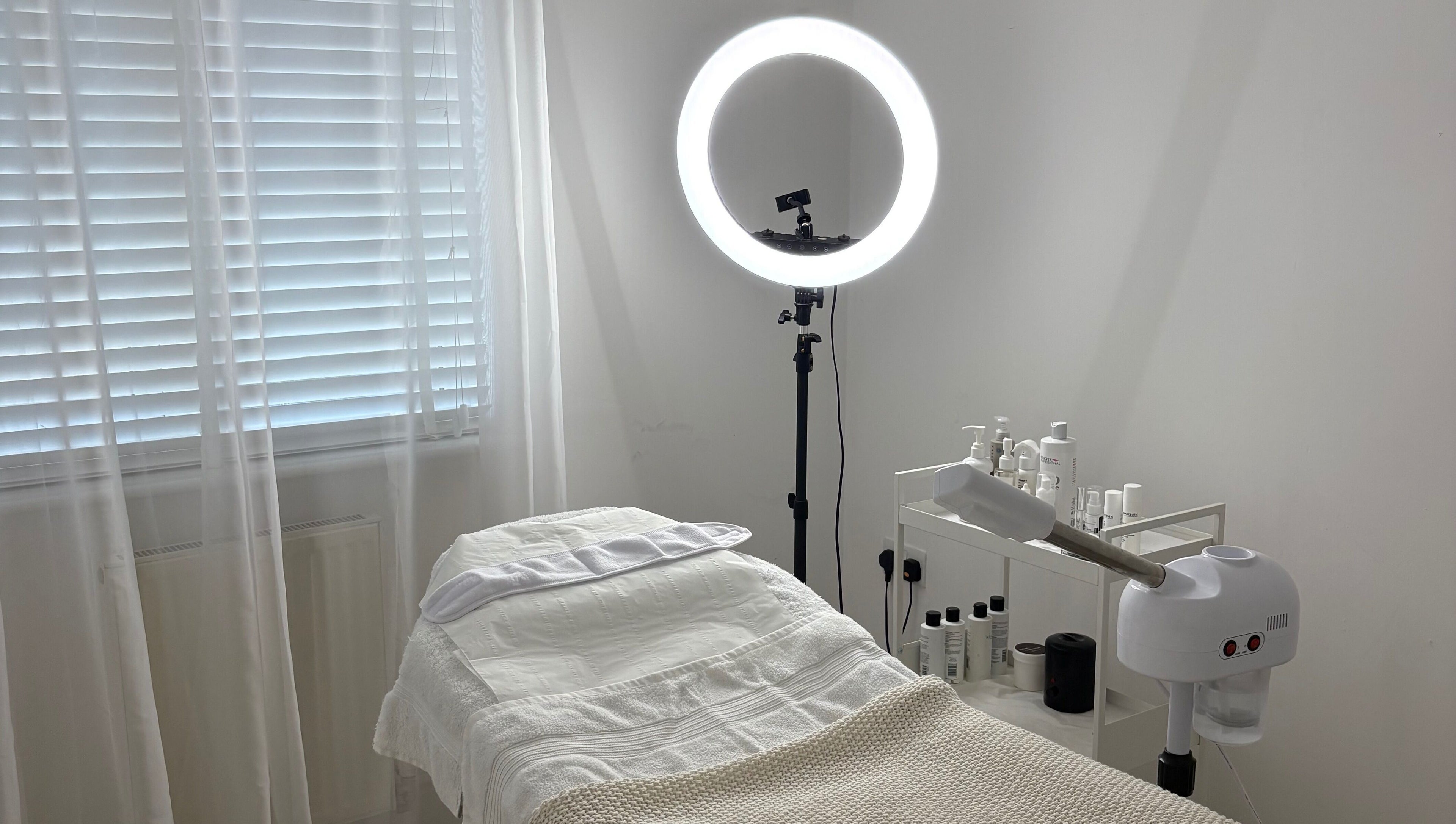 Serene treatment room at SknandSculpt, Ely, England, GB, featuring a cozy bed and skincare products.