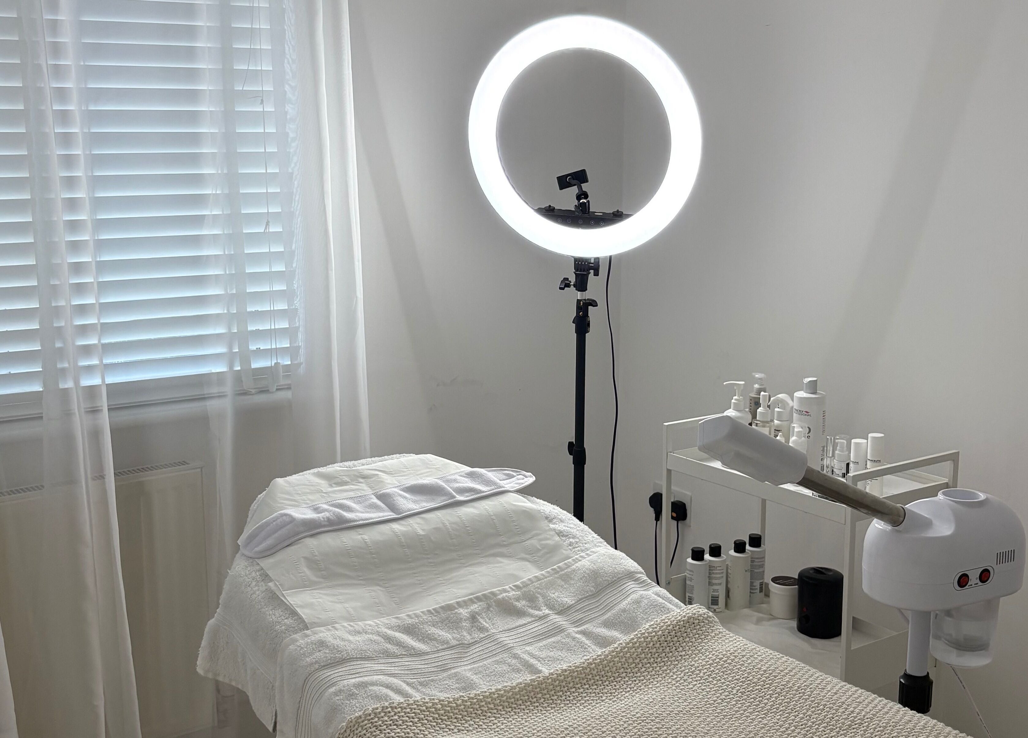 Serene treatment room at SknandSculpt, Ely, England, GB, featuring a cozy bed and skincare products.