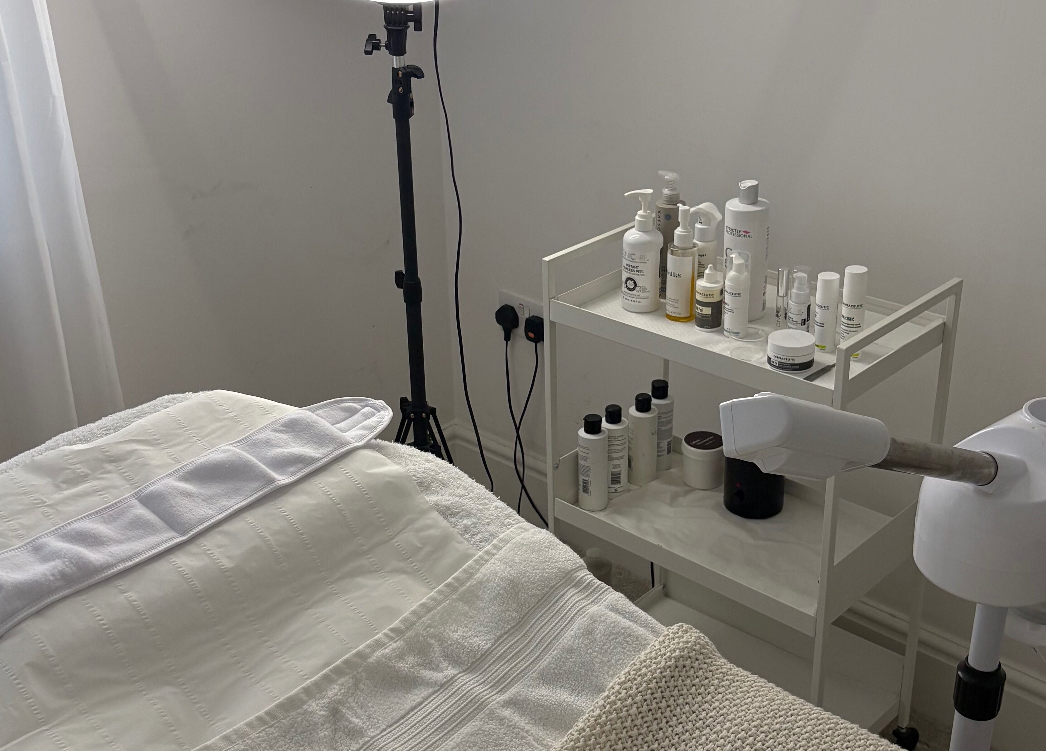 Tranquil treatment room at SknandSculpt, Ely, England, GB, featuring a massage table and skincare products.