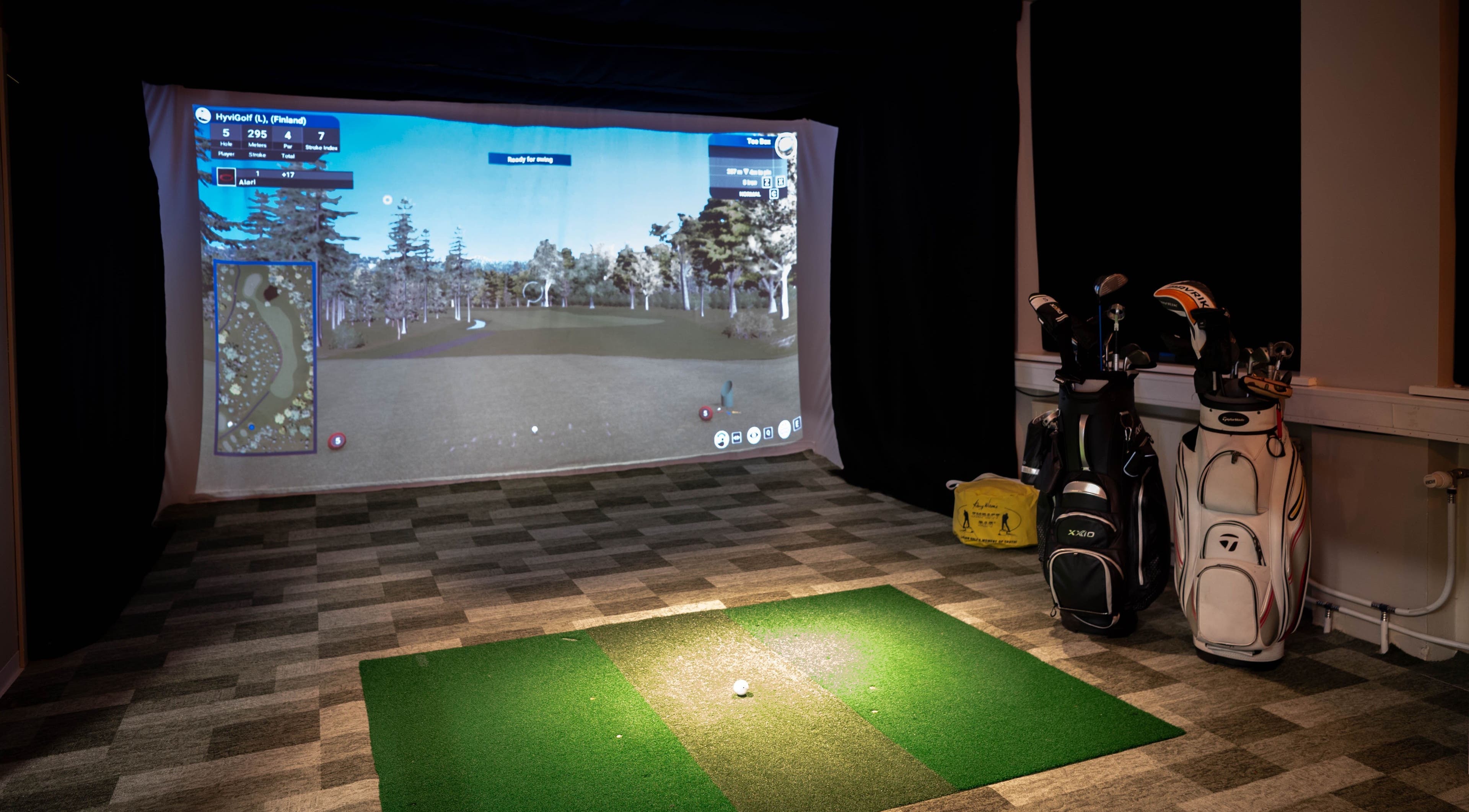 Golf simulator setup at ToaGolf, Tallinn, Harju maakond, EE, showcasing virtual golf course screen and clubs.