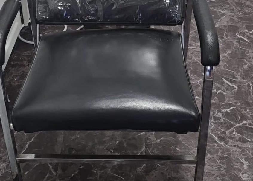 Luxurious black salon chair at Scissors & Serums, Whitby, Ontario, CA offering comfort and style.