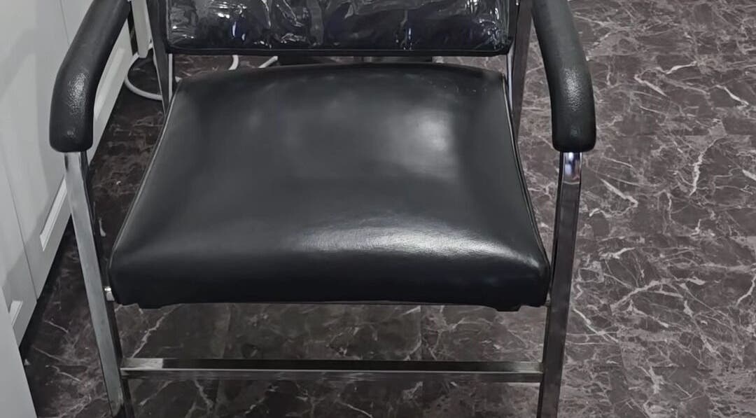 Luxurious black salon chair at Scissors & Serums, Whitby, Ontario, CA offering comfort and style.