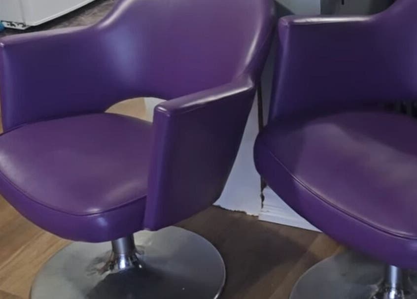 Two sleek purple chairs at Scissors & Serums, Whitby, Ontario, CA enhancing salon's modern ambiance.