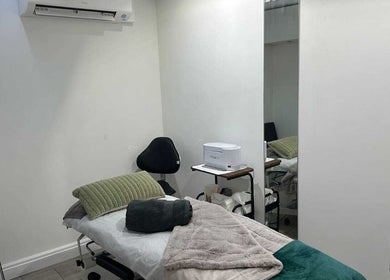 Cozy treatment room at Innior Ltd, Teddington, England with massage table and white walls.