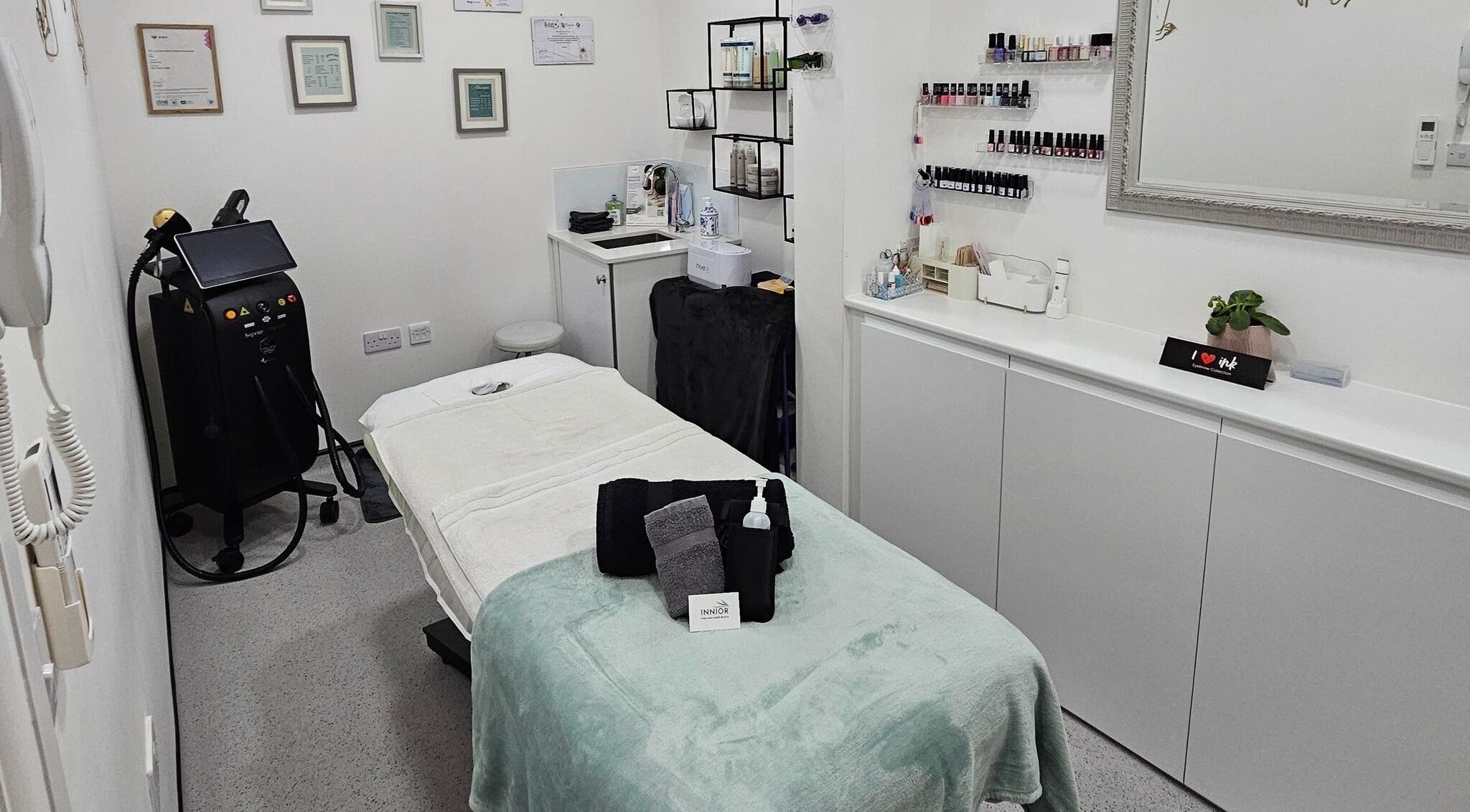 Serene treatment room at Innior Ltd, Teddington, England, GB, featuring a massage table and beauty products.