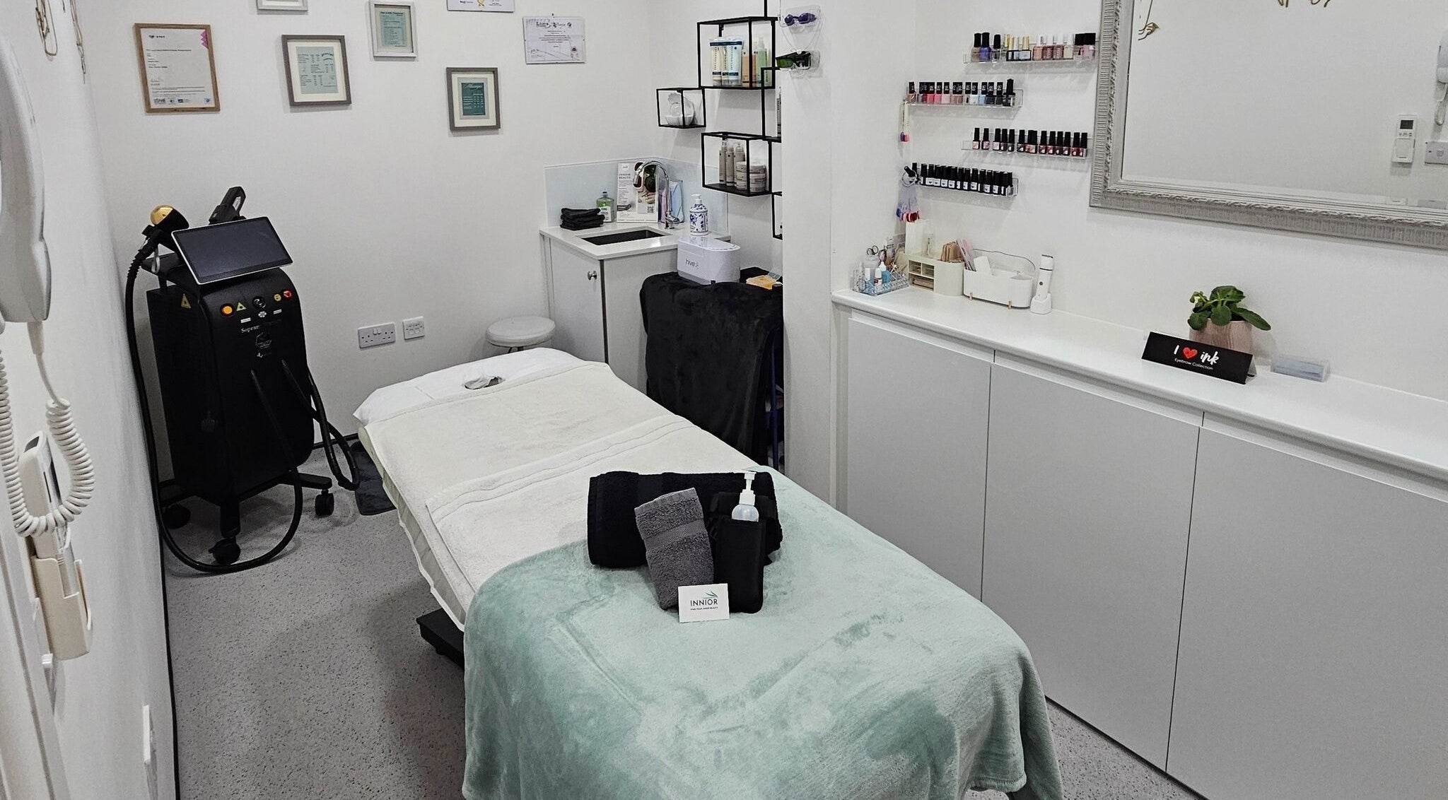 Serene treatment room at Innior Ltd, Teddington, England, GB, featuring a massage table and beauty products.