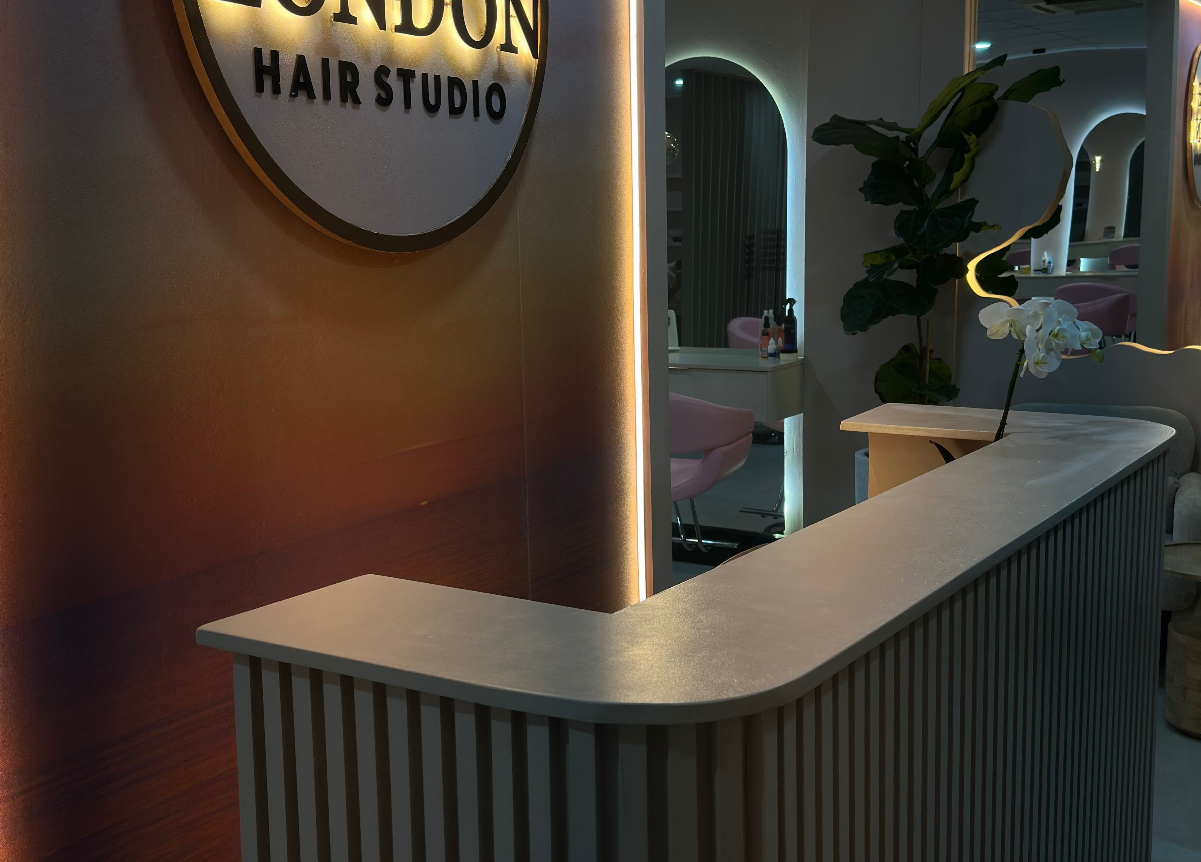 Elegant reception area of Londie London Hair Studio in Sandton, Gauteng, ZA with modern design and warm lighting.