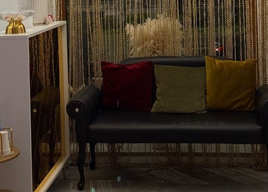 Затишний куточок у T&T studio, Щецін, Західнопоморське воєводство, Польща з чорним диваном і подушками.