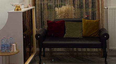 Затишний куточок у T&T studio, Щецін, Західнопоморське воєводство, Польща з чорним диваном і подушками.