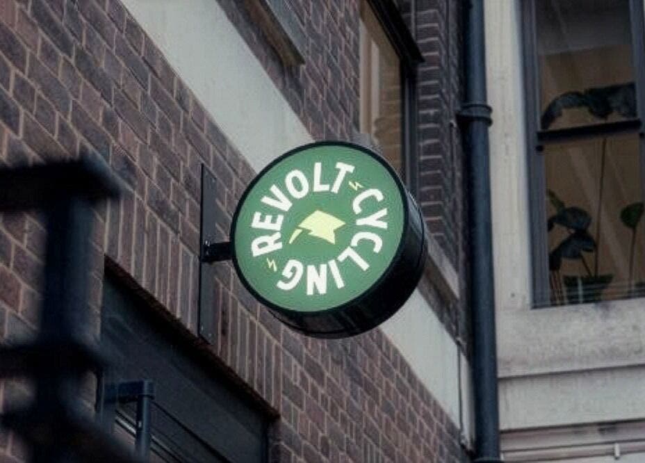 Sign of Revolt Cycling on a brick facade in London, England, GB, highlighting the venue's location.