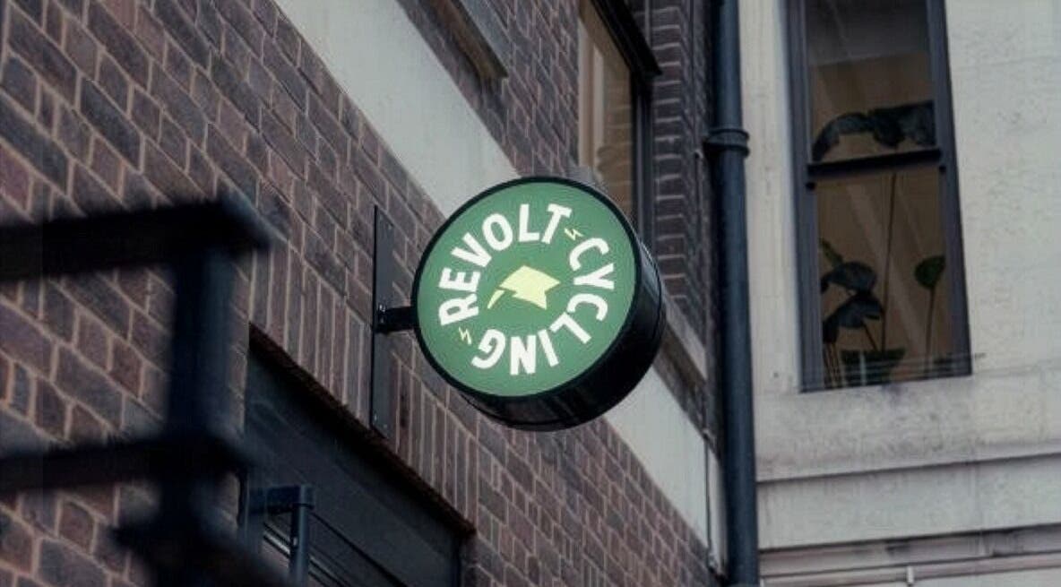 Sign of Revolt Cycling on a brick facade in London, England, GB, highlighting the venue's location.