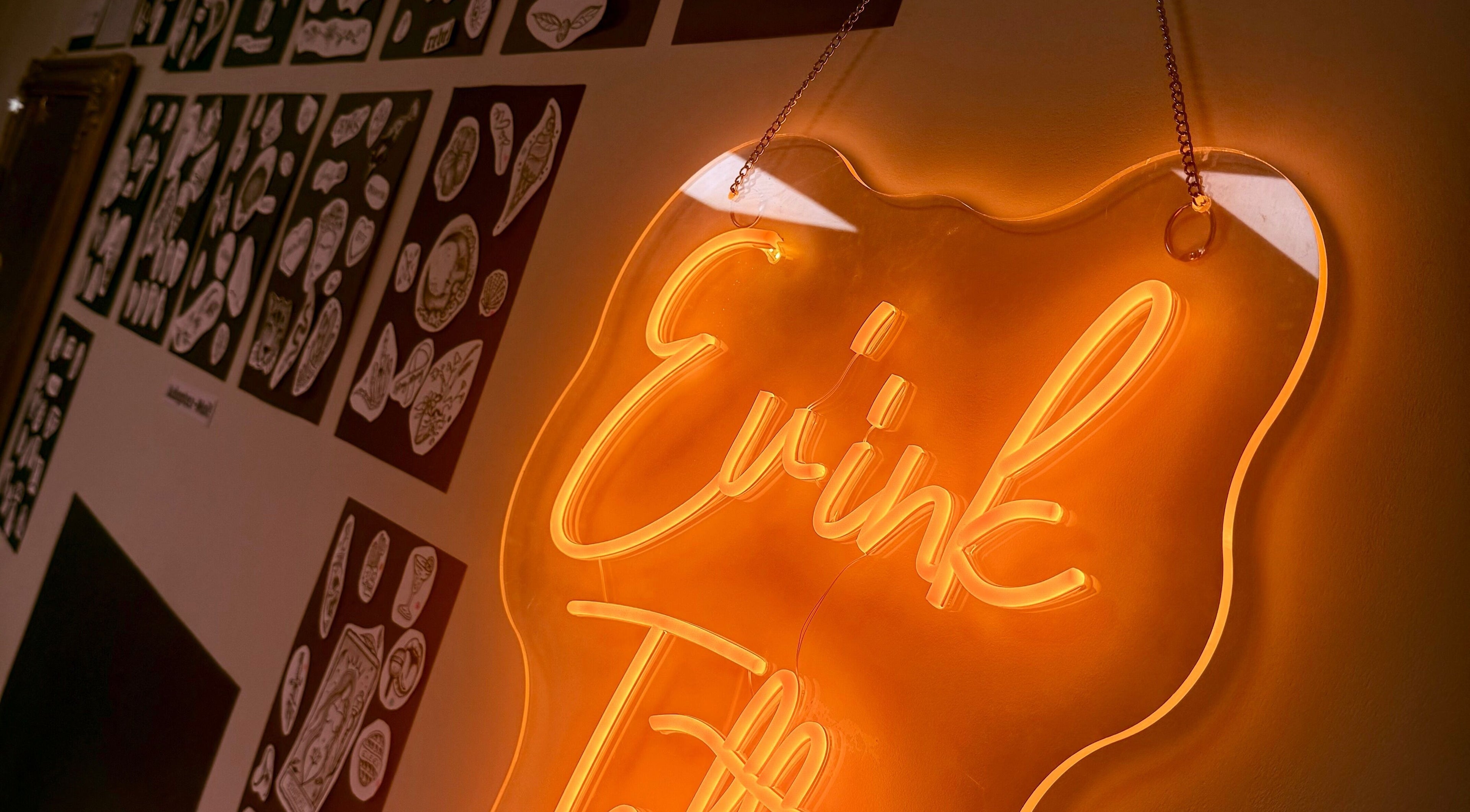 Signe néon lumineux Ev’ink Tattoo à Saint-avé, Bretagne, FR illuminant une galerie de motifs artistiques.