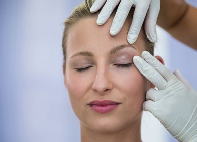 Soin du visage expert à In Dermo, Milhaud, Occitanie, FR. Mains gantées appliquent un traitement délicat.