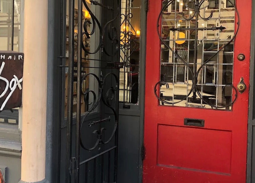 Stylish red entrance of Red Square Salon in Vancouver, British Columbia, CA with elegant ironwork.