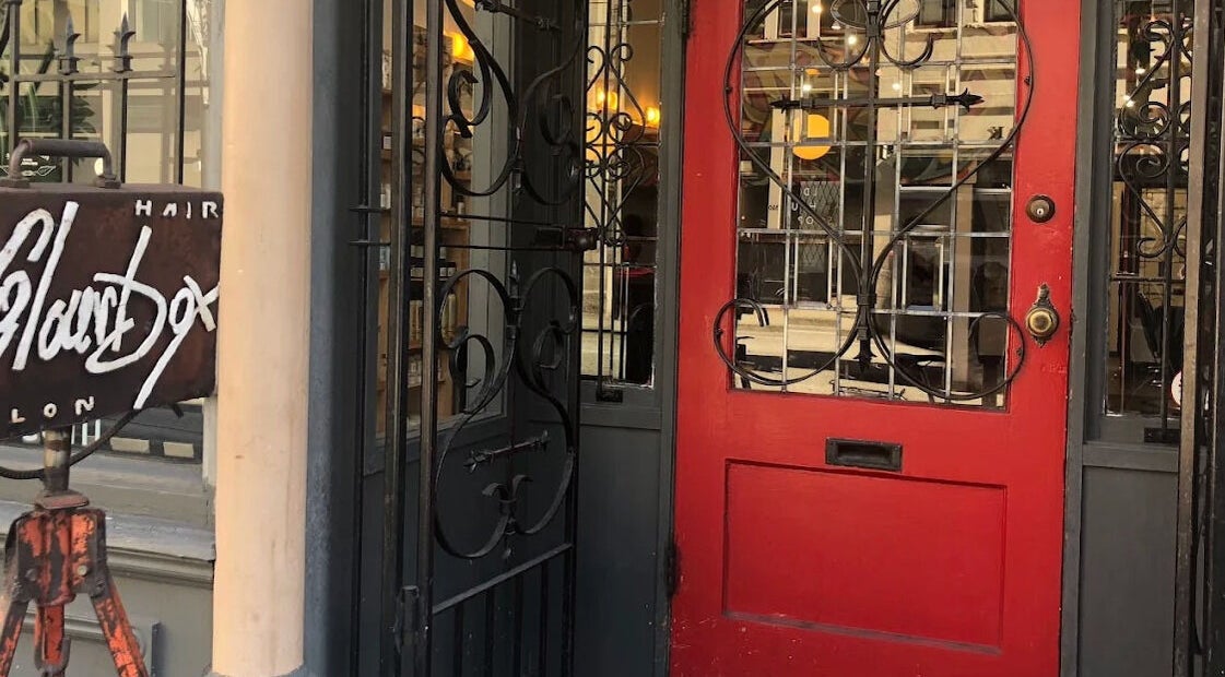 Stylish red entrance of Red Square Salon in Vancouver, British Columbia, CA with elegant ironwork.
