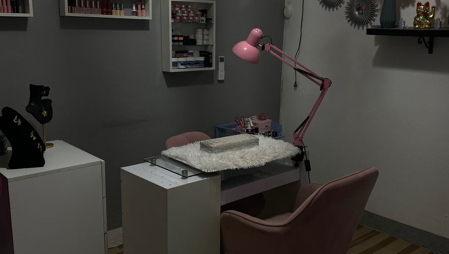 Estación de manicura en Nails by Stef, Guayaquil, Guayas, EC, equipada con lámpara rosa y silla cómoda.