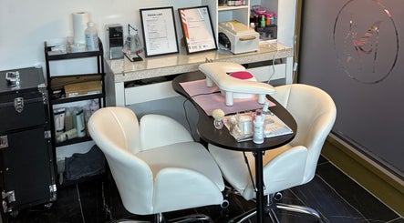 Nail care station at Stiletto Vault, Wembley, England, GB, showcasing cozy white chairs and manicure tools.
