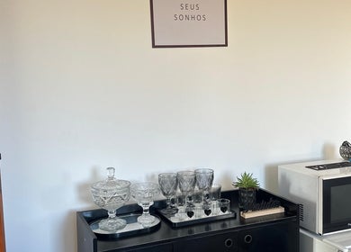 Espaço acolhedor da Studio Valeska Carvalho em São Paulo, São Paulo, BR com louças e placa inspiradora.