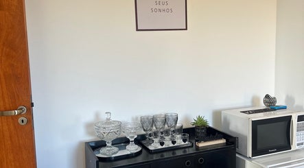 Espaço acolhedor da Studio Valeska Carvalho em São Paulo, São Paulo, BR com louças e placa inspiradora.