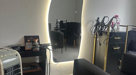 Espelho iluminado no Studio Valeska Carvalho, São Paulo, São Paulo, BR, refletindo cadeiras e equipamento de beleza.