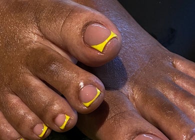 Bright yellow accented pedicure at Kshine Aesthetics in Willemstad, Curaçao, CW, showcasing nail artistry.