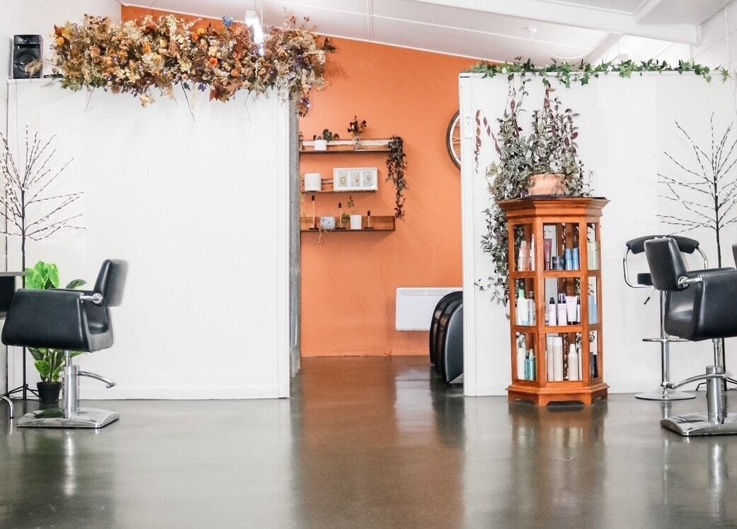 Interior of Clippers Hair Studio in Ashburton, NZ, featuring modern chairs and elegant decor.