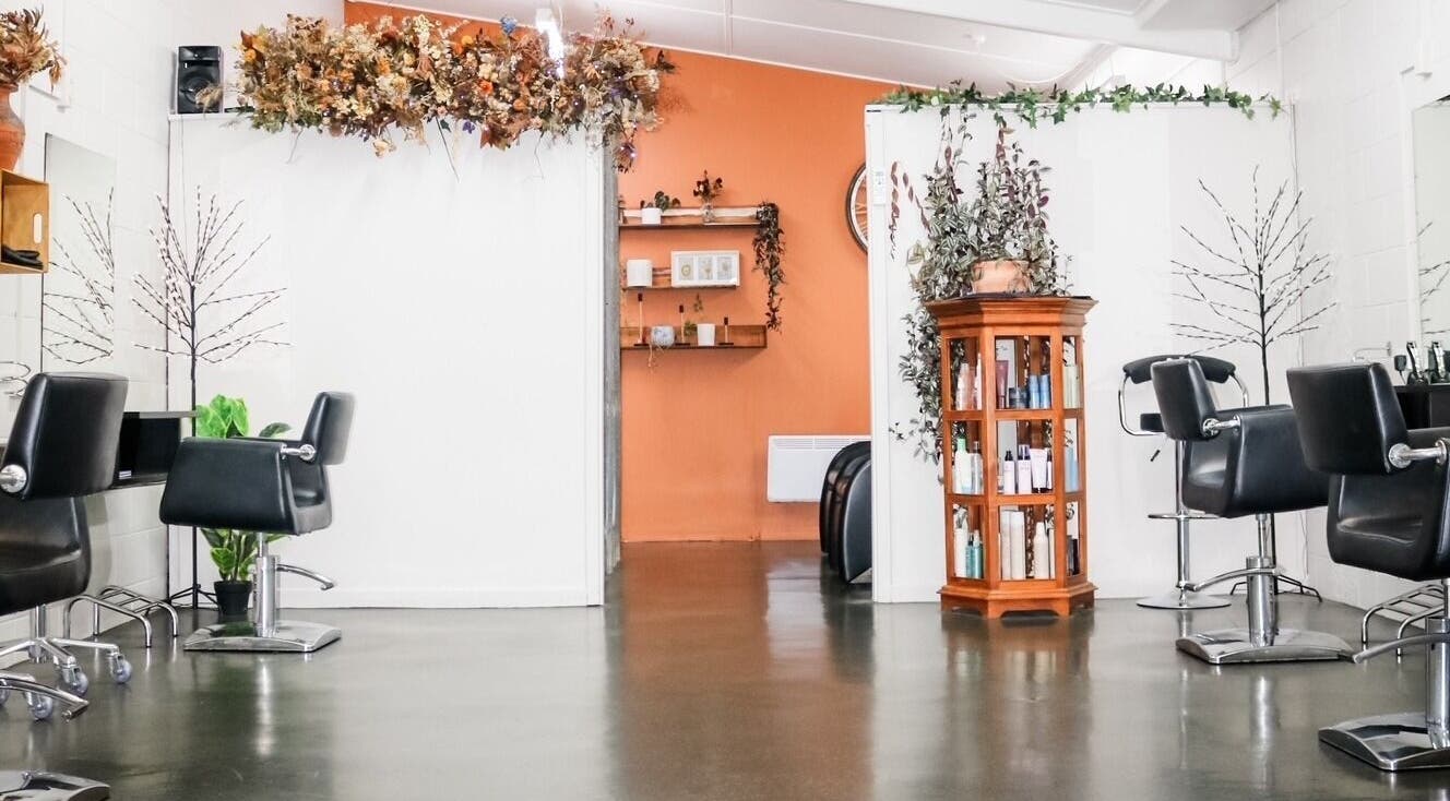 Interior of Clippers Hair Studio in Ashburton, NZ, featuring modern chairs and elegant decor.