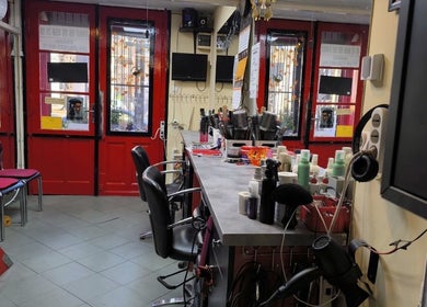 Anna fodrászat belső tere, Budapest, Magyar, HU. Élénk piros ajtók és modern fodrászállomás.