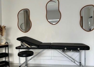 Table de massage élégante à Beleza Institut, Groslay, Île-de-France, FR avec miroirs artistiques et plantes.