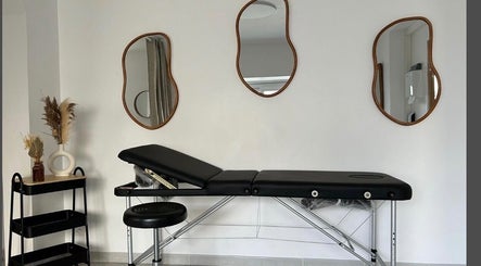 Table de massage élégante à Beleza Institut, Groslay, Île-de-France, FR avec miroirs artistiques et plantes.