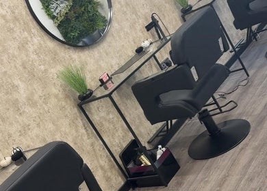 Modern salon station at Hair by HRL in Dundee, Scotland, GB, featuring sleek chairs and calming decor.