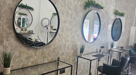 Modern salon interior at Hair by HRL, Dundee, Scotland, GB, with sleek mirrors and stylish decor.