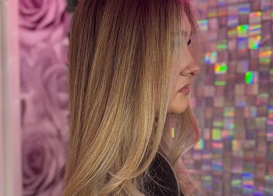 Side view of sleek blonde hairstyle at ShanayaOakes.hair, Bath, England, GB with vibrant pink backdrop.