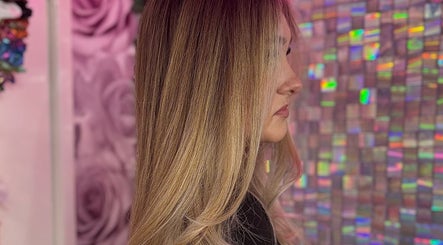 Side view of sleek blonde hairstyle at ShanayaOakes.hair, Bath, England, GB with vibrant pink backdrop.