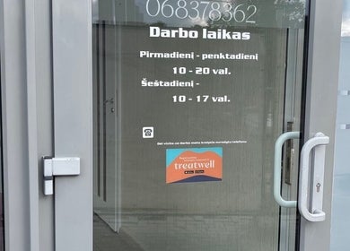 Вход в Manicure & Pedicure Pašilaičiai, Вильнюс, с расписанием работы на двери.