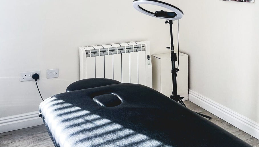 Treatment room at The Brow Rehab, Little Lever, England, GB with a black massage table and ring light.