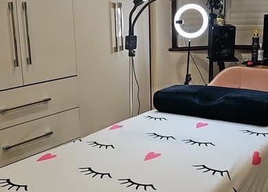 Интерьер студии Dora Lash в Чигвелле, Англия, с уютной кушеткой для процедур и теплым светом.