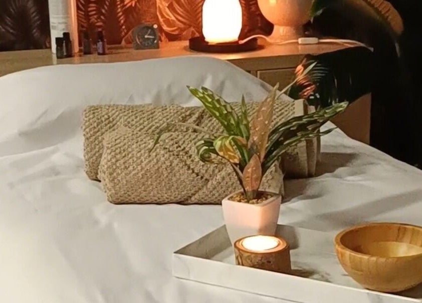 Sala de terapia no Centro Terapêutico Cátia Barbosa em Cervães, Braga, PT. Mesa com planta, vela e toalha.