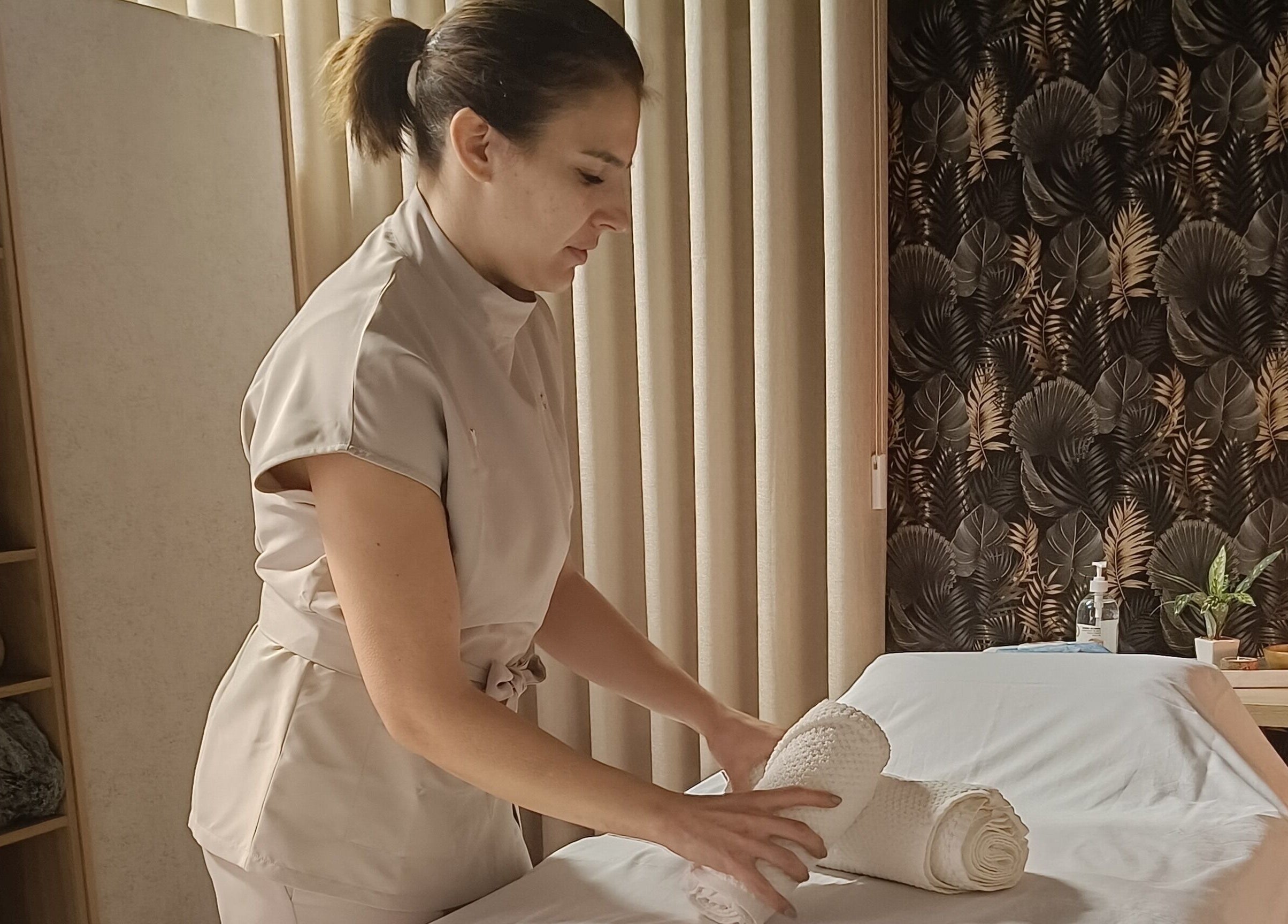 Terapeuta organizando toalhas no Centro Terapêutico Cátia Barbosa em Cervães, Braga, PT.