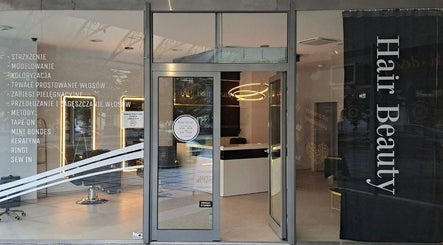 Wejście do AP HAIR BEAUTY w Częstochowie, Województwo Śląskie, PL, z nowoczesnym wystrojem i stylowym oświetleniem.