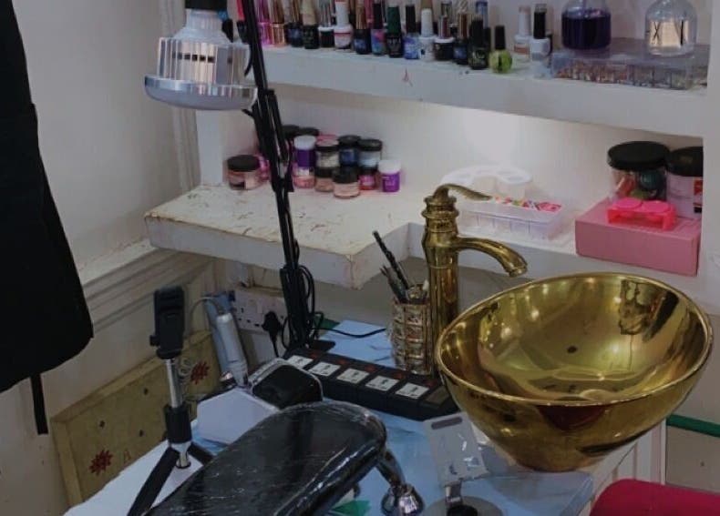 Nail care station with gold sink at Nailed by Ronnie in Ikeja, Lagos, NG. Elegant tools and polish collection displayed.