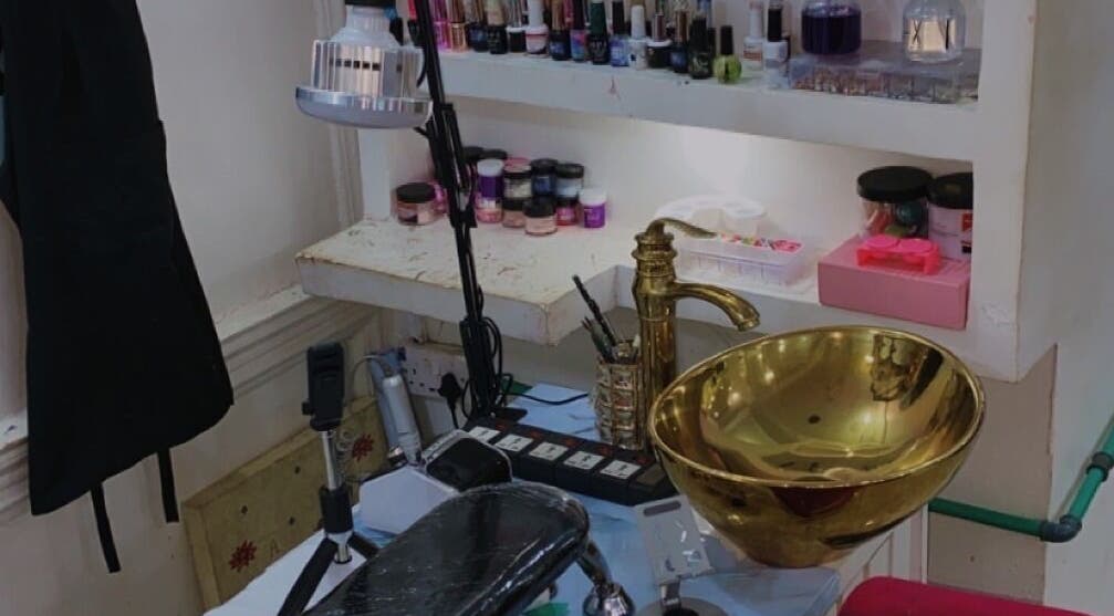 Nail care station with gold sink at Nailed by Ronnie in Ikeja, Lagos, NG. Elegant tools and polish collection displayed.