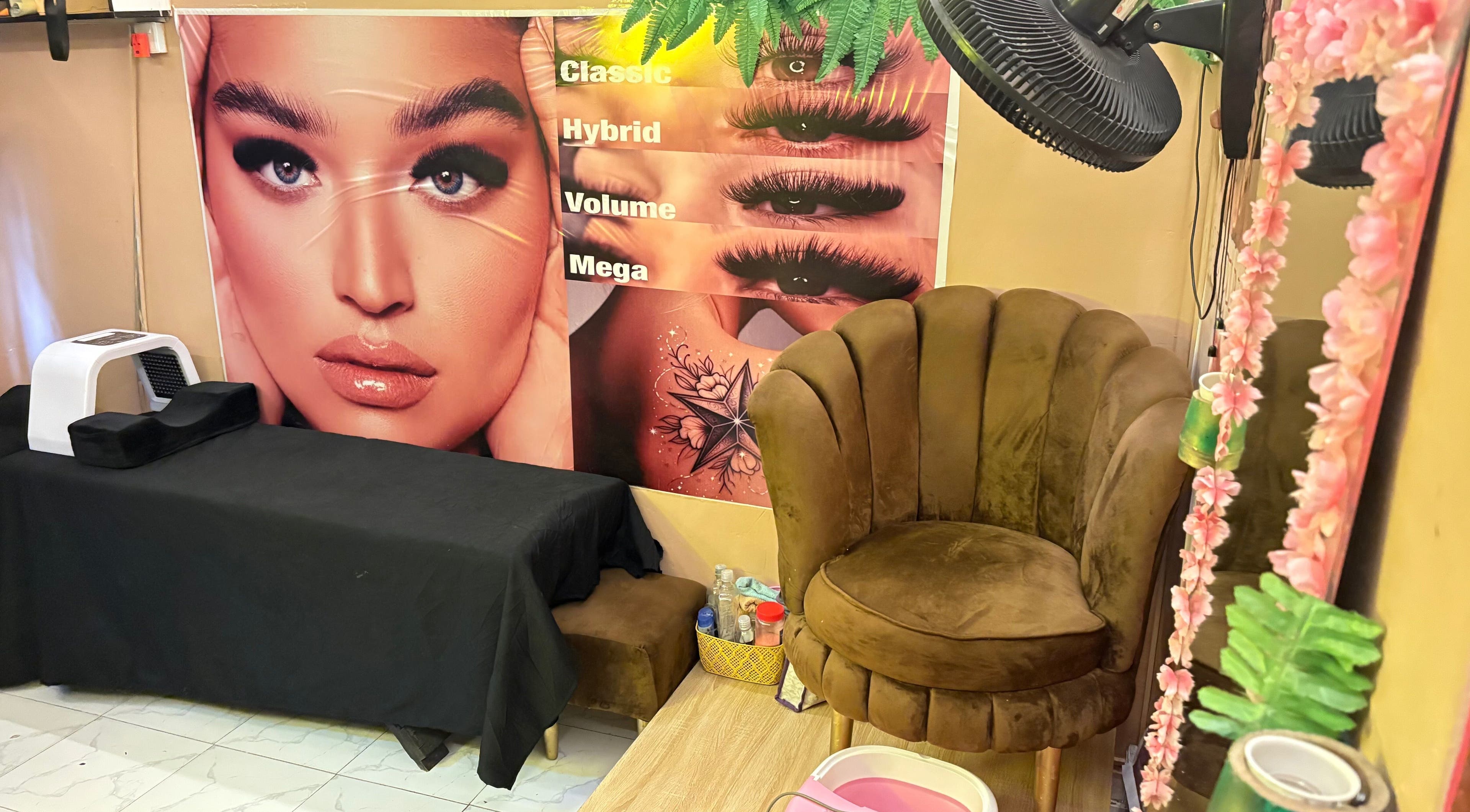 Cozy seating at Nailed by Ronnie, Ikeja, Lagos, NG, with lash styles displayed on the wall.