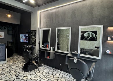 Elegante interno di G barber shop a Roma, Lazio, IT con specchi e sedie moderne.