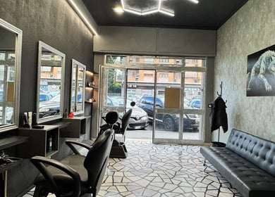 Interno elegante di G barber shop a Roma, Lazio, IT con specchi e sedie moderne.