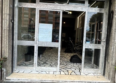 Ingresso del G barber shop a Roma, Lazio, IT, con porta in vetro e interni moderni visibili dall'esterno.