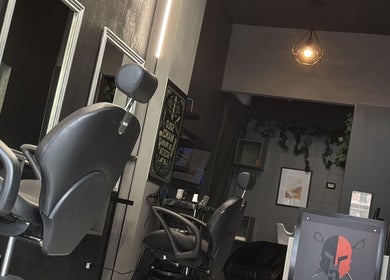 Interno elegante del G barber shop a Roma, Lazio, IT con sedie e specchi moderni.