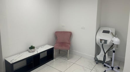 Cozy corner at Aesthetic Beauty Clinic, Kingston Upon Thames. Features chic pink chair and modern equipment.