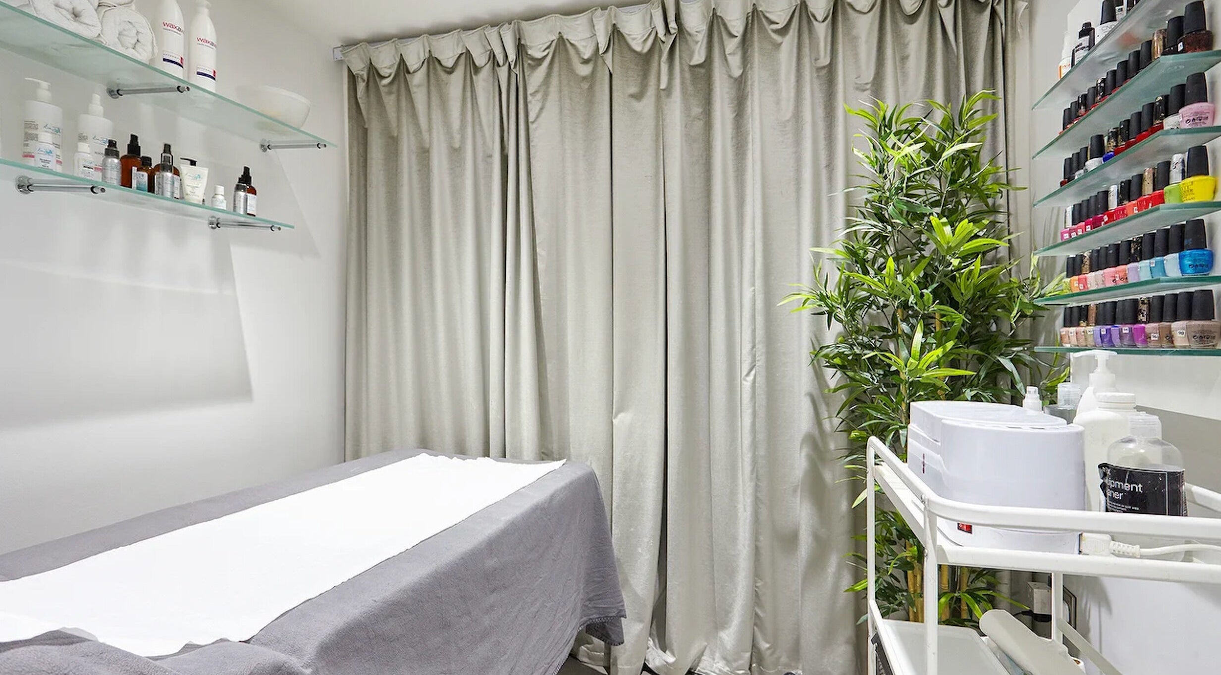 AF Beauty treatment room with cozy bed and beauty products in Kingston Upon Thames, England, GB.